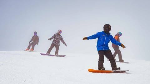 Students snowboarding on a day ski trip